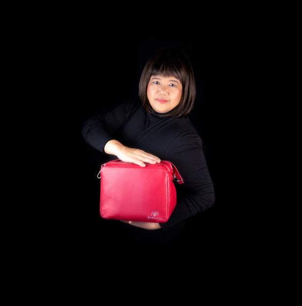 Image of Corie Laraya-Coutts modeling a fuchsia colored Bella, Thermal Designer Handbag. Corie is the CEO of La Coutts Toronto