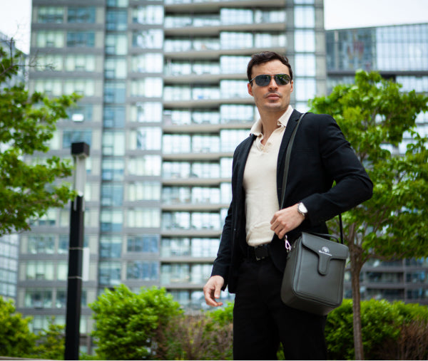 Image of a guy modeling the grey leather Duncan thermal designer handbag by La Coutts Toronto
